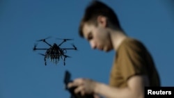 Un militar ucrainean controlează o dronă în timpul unui zbor, într-o locație secretă din regiunea Harkov, Ucraina, aprilie 2025.