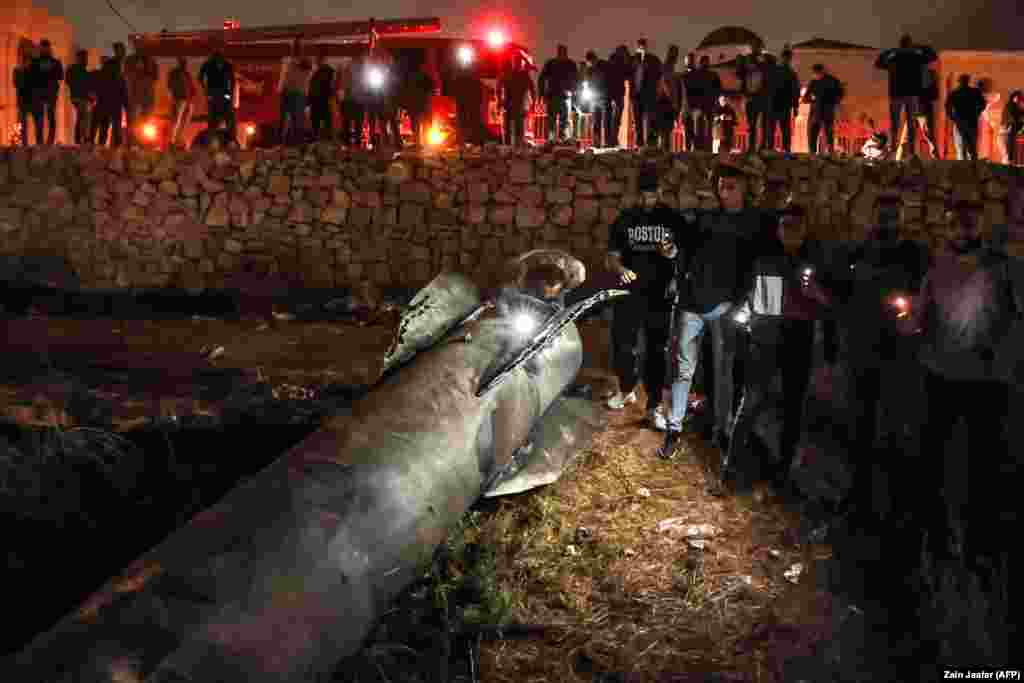 Palestinians in Ramallah gather around a fallen rocket after the Iranian attack.&nbsp;