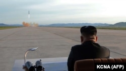 Северокорейский лидер Ким Чен Ын наблюдает за пуском баллистической ракеты Hwasong-12. Сентябрь 2017 года.