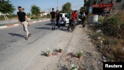 Muškarac gleda mesto obeleženo saksijama cveća gde su izraelske snage ubile tri Palestinca, u Dženinu 10. juna 2021.
