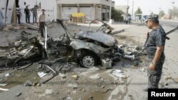 Iraqi security personnel inspect the site of a car-bomb attack in Kirkuk on August 16.