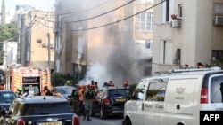 Ізраільскія сілы бясьпекі і супрацоўнікі экстраных службаў сабраліся на месцы падзеньня іранскай ракеты ў Рамат-Гане каля Тэль-Авіву. 3 сакавіка 2026 года