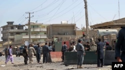 Afghan policemen inspect the site of a suicide attack in Lashkar Gah, capital of Helmand province on October 8, 2014.