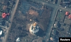 O imagine din satelit surprinde groapa comună, săpată în spatele bisericii din Bucea, Ucraina.