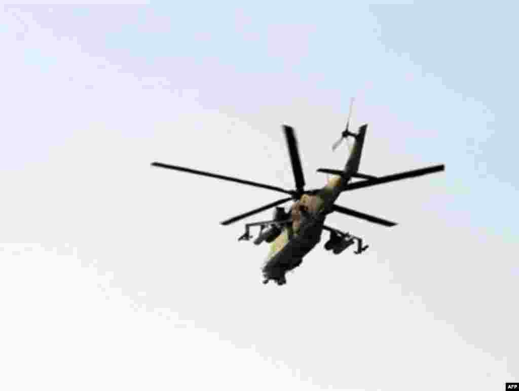 GEORGIA, GORI : A Russian military helicopter flys over a main road connecting South Ossetia's main city of Tskhinvali with the Georgian town of Gori on August 10, 2008. As helicopter gunships hovered over Georgia's breakaway province of South Ossetia, newly occupied by Russian forces, a stream of bedraggled people fled the area, testifying to days of heavy bombardment.