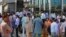 People stand outside an office building after an earthquake is felt in Islamabad, Pakistan, on May 9.