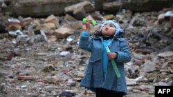 Сирийская девочка среди развалин пускает мыльные пузыри, январь 2017, юг Сирии