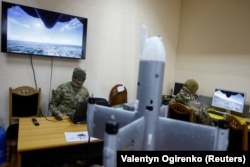 Инструктор и сотрудник частного охранного предприятия используют тренажеры для обучения полетам на беспилотнике-перехватчике, Украина, 8 апреля 2026 года