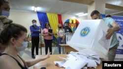 Membrii unei comisii electorale locale se pregătesc să numere buletinele de vot exprimate în timpul alegerilor parlamentare din 11 iulie 2021.