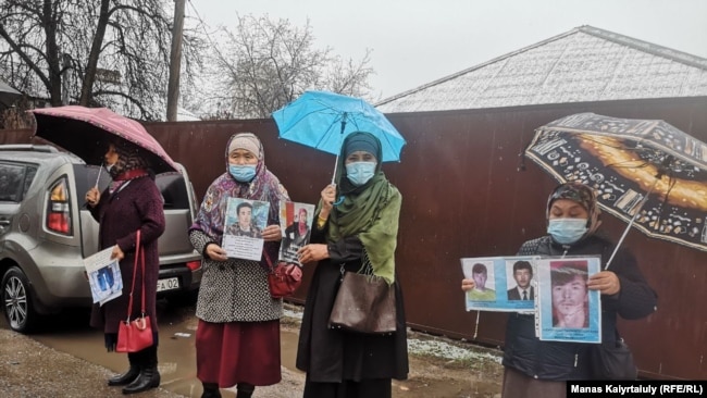 Женщины держат в руках фотографии своих родных, по их словам без вести пропавших либо удерживаемых под стражей в Китае.