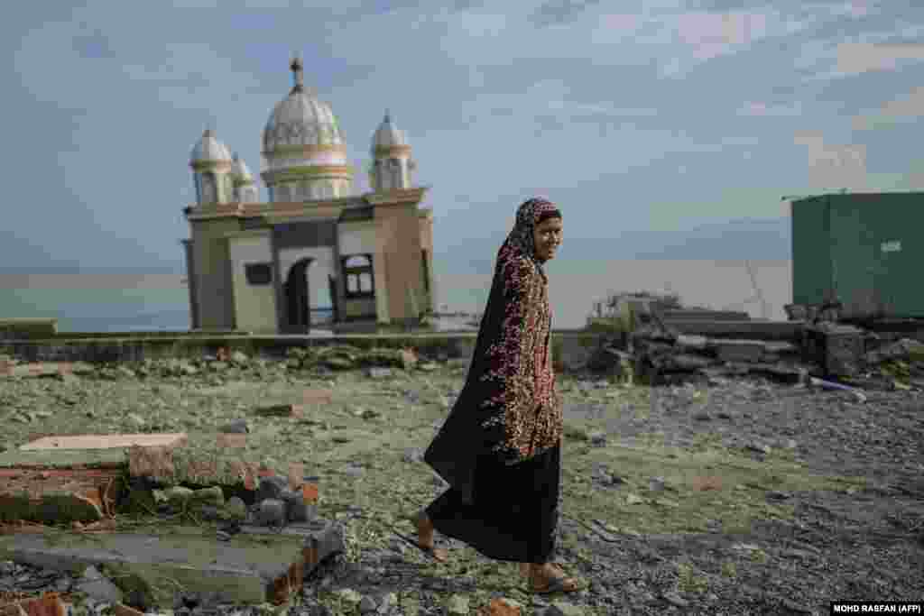 A resident walks past a damaged mosque on the tsunami-devastated coast of Palu in Indonesia&#39;s Central Sulawesi after an earthquake hit the area on September 28. The death toll has passed 1,400, with time running out to rescue survivors and the UN warning of &quot;vast&quot; unmet needs that have fueled looting. (AFP/Mohd Rasfan)