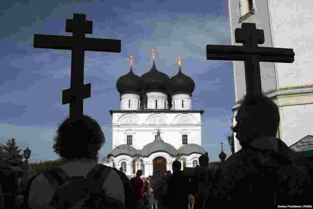 Pilgrims hold crosses as they approach the Dormition Cathedral, part of the Trifonov Monastery, at the end of the procession.