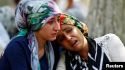 Women mourn as they wait in front of a hospital morgue in the Turkish city of Gaziantep after a suspected bomber targeted a wedding celebration in the city, killing at least 51.