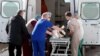 UKRAINE -- Medical workers load a patient to an ambulance, outside a hospital for patients infected with the coronavirus disease (COVID-19) in Kyiv, February 22, 2021