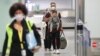 GERMANY -- A man holds a baby as he arrives with his family among the first German and Afghan evacuees from Kabul, at Frankfurt International Airport in western Germany in the early hours of August 18, 2021