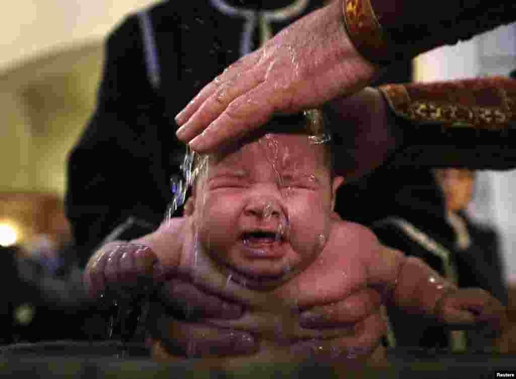 A baby is baptised during a mass baptism ceremony on the Orthodox feast of Epiphany in Tbilisi, Georgia, on January 19. (Reuters/​David Mdzinarishvili)