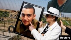 ჰამასის მძევლობაში მყოფი ედან ალექსანდერის ბებია ვარდა ბენ ბარუხი შვილიშვილის ფოტოთი ისრაელის და ღაზის სექტორის საზღვართან. 2025 წლის 20 აპრილი 