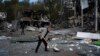 An employee cleans up debris at the remains of a car shop that was destroyed after a Russian attack in Zaporizhzhya on October 11.