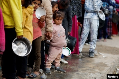 Palestinezët duke pritur në radhë për të marrë ushqim në Rafah.