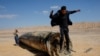 A man jumps off the apparent remains of a ballistic missile lying in the desert, following an attack by Iran on Israel, near the southern Israeli city of Arad.&nbsp;