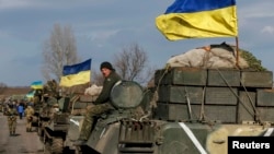 A convoy of Ukrainian armed forces, including armored personnel carriers, military vehicles, and cannons, prepares to move as the troops pull back from the Debaltseve region, in Blahodatne, on February 27.