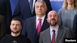  Ukrainian President Volodymyr Zelenskiy (left) and Hungarian Prime Minister Viktor Orban (top) pose for a family photo next to European Council President Charles Michel at the European leaders summit in Brussels on February 9.