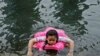 Kislány hűti magát egy csatorna vizében Pekingben 2023. július 3-án