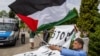 Tüntetők palesztin zászlókkal és „Állítsuk meg a népirtást Gázában” feliratú transzparenssel várták az Élet Menetének résztvevőit az egykori Auschwitz-Birkenau Emlékmű és Múzeumnál 2024. május 6-án