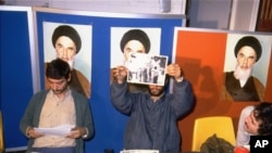 Iranian student spokesmen hold up photos of blindfolded American hostages, during a press conference in Tehran Monday November 5, 1979. The hostages are members of the staff of the United States Embassy in Tehran, which was stormed by students November 4