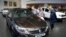 File Photo In this Thursday, July 16, 2015 photo, Iranians look at a Renault sedan at a dealership in northern Tehran, Iran. 
