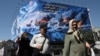 People in Tehran walk past an Iranian propaganda billboard about the Strait of Hormuz on September 16. 