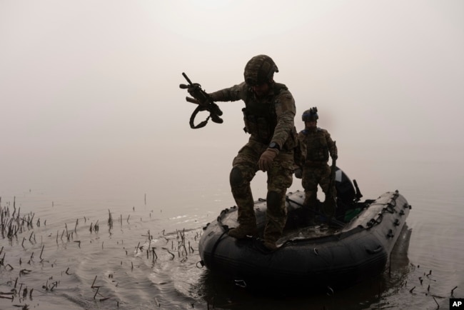 Un soldato ucraino salta da una barca sulla riva del fiume Dnepr in prima linea vicino a Kherson il 15 ottobre.