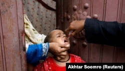 A girl receives the polio vaccine in a low-income neighborhood of Karachi on July 20. Pakistan, along with Afghanistan, has the world's only remaining cases.