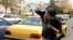 An Iranian taxi driver cools down by splashing water on his face on a street amid soaring temperatures in Tehran on July 22.