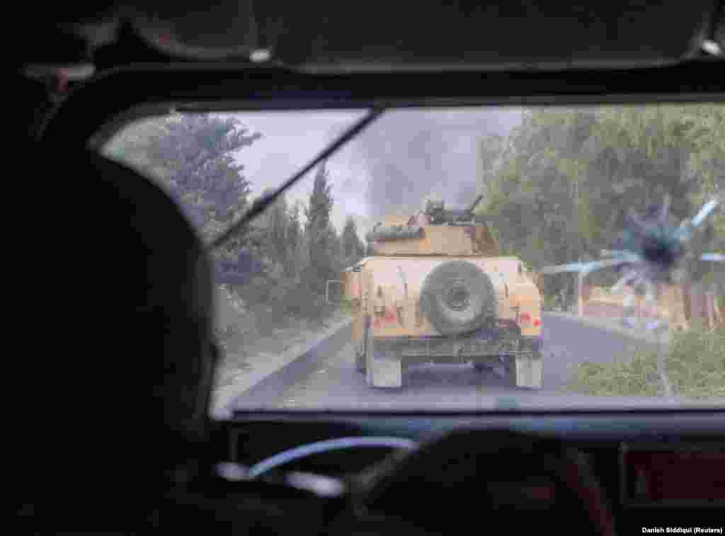 An Afghan special forces soldier fires at Taliban militants during the rescue mission of a police officer besieged at a check post in Afghanistan&#39;s Kandahar Province on July 13.