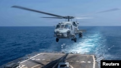 Photo from March shows a helicopter taking off from the flight deck of the guided-missile destroyer USS Pinckney.