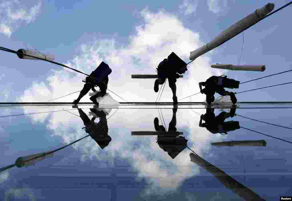 Window cleaners replace banners on the building of Jugoslovensko Dramsko theatre in Belgrade. (Reuters/Marko Djurica)