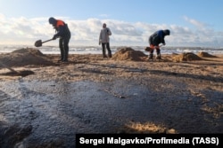 Volunteers scoop up oil-soaked sand on the Krasnodar region coastline.