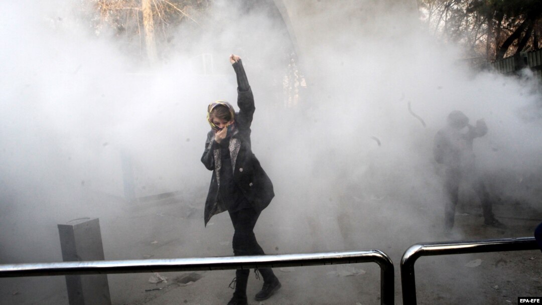 A young woman raises her fist aloft as Iranian students clash with riot police in Tehran during antigovernment protests that rocked Iran for around two weeks at the turn of the year. 