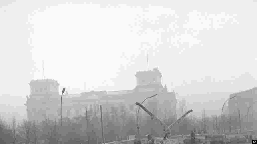 Войскі Ўсходняй Нямеччыны ўсталёўваюць Бэрлінскую сьцяну каля Рэйхстагу ў лістападзе 1961 году. &nbsp;