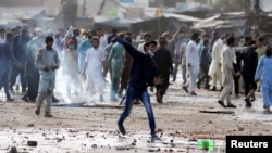 A supporter of the Islamist Tehrik-e Labaik party hurls stones toward police during a protest against the arrest of their leader in Lahore, on April 13. 