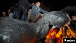 A statue of Soviet state founder Vladimir Lenin is toppled by protesters during a rally organized by pro-Ukraine supporters in the center of the eastern city of Kharkiv on September 28.