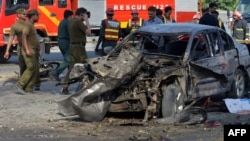 Pakistani security officials inspect the site of the deadly explosion in Lahore on July 24.