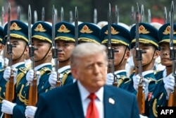 Прэзыдэнт ЗША Дональд Трамп праходзіць паўз ганаровую варту на цырымоніі прывітаньня ў Доме народных сходаў у Пэкіне 14 траўня