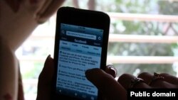 Пользователь Facebook с телефоном. 