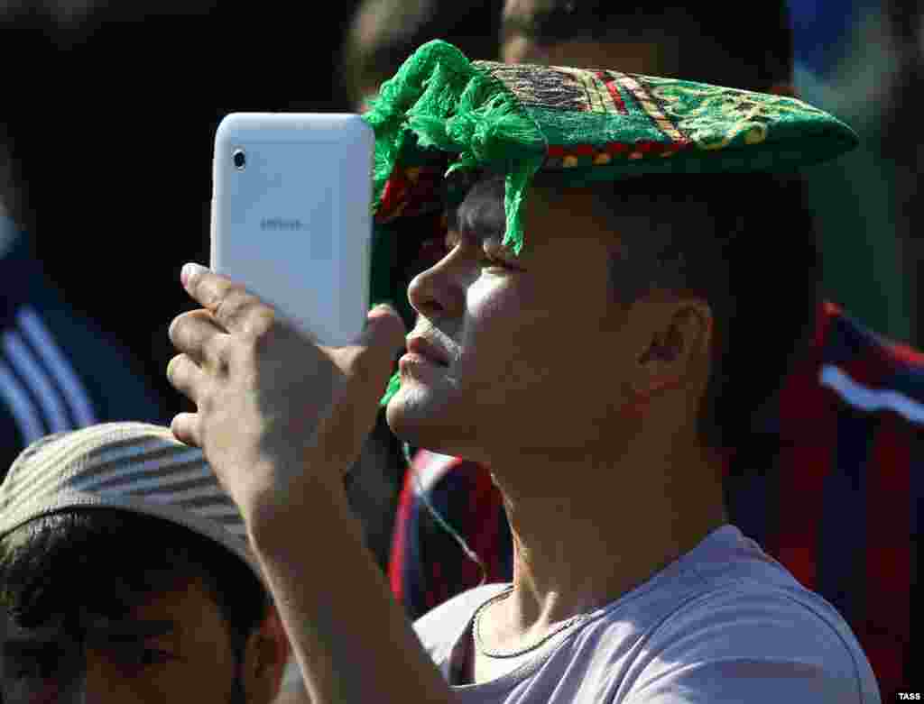 A young man uses his smart phone to chronicle his Eid al-Fitr experience in Moscow.