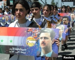  Момичета носят портрета на Башар Асад по улиците на Кардаха на 13 юни 2000 година преди погребението на починалия сирийски президент Хафез Асад. 