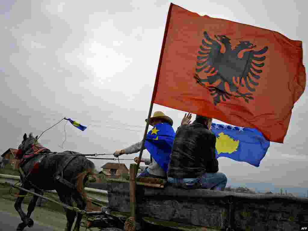 Kosovars fly the flags of Albania and Kosovo from a horse-drawn cart near the town of Mitrovica. - Kosovo on February 17 marked the second anniversary of its unilateral declaration of independence from Serbia. Photo by Armend Nimani for AFP 