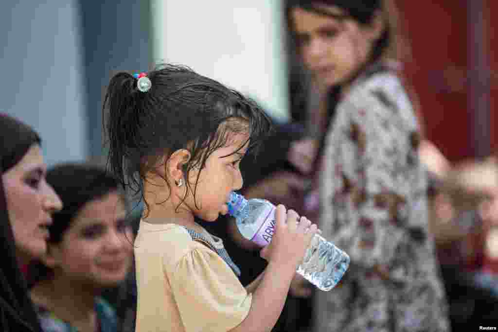 Një vajzë e vogël duke pirë ujë në Aeroportin e Kabulit, teksa bëhen përgatitje për evakuim nga Afganistani.