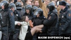 Полицейские держат девушку во время акции протеста. Москва, 26 марта 2017 года.